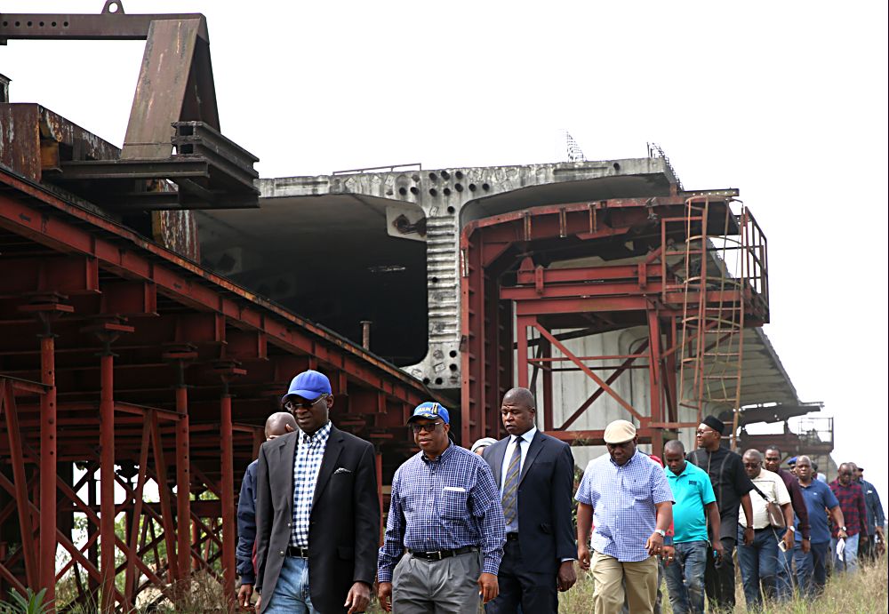 Hon Minister of Power Works  Housing Mr Babatunde FasholaSANleft Director Highways Construction and Rehabilitation Engr Yemi Oguntominiyi 2nd leftDirector Highways South South Zone Engr Charles Okonmah 4th from left  Federal Controller of Works Rivers State Engr Nebeolisa Anako 6th from leftand others during the Hon Ministers inspection tour of the Bodo  Bonny Road with Bridges across Afa Opobo and Nanabie Creeks in Rivers State on the third day of his inspection tour ofHighway Projects in the South  South Zone of the country on Saturday 18th February 2017 The contract for the Project in the background was first awarded in 1998 and works started 2003 it dragged on till 2014 when contractor abandoned site but with provision of funding by the Federal Government construction work by Julius Berger Nigeria Plc is set to resume on the site