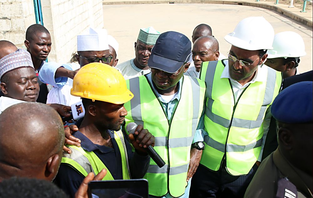 Hon Minister of Power Works  Housing Mr Babatunde Fashola SAN middle interacting with one of the artisans employed by the contractor Mabon Nigeria Limited Mr Jeremiah Barnabasleft and Mabon Representative Mr Christoperright  during the HonMinister s inspection tour  of the 40MW Hydro Power Plant in Dadin Kowa Gombe  State on Day Three of his inspection tour of Highway Projects in the North East Zone on Saturday 18th March 2017