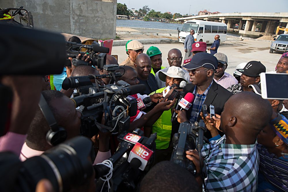 Hon Minister of Power Works  Housing Mr Babatunde FasholaSANleft speaking with Journalists shortly after his inspection tour of the ongoing construction work on the Rehabilitation of Access Road to ApapaTin Can Island Port  NNPC Depot Atlas Cove including the construction of a new bridge running parallel to the existing bridge from Liverpool Roundabout across Port Novo Creek in Lagos State on Day Three of his inspection tour of Highway Projects in the South West Zone of the country on Saturday 25th March 2017