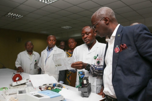 Hon Minister of Power Works  Housing Mr Babatunde FasholaSAN  interacting with one of the Engineers Mr Jonathan Isise 2nd right during an inspection visit to the NEMSA National Meter Test Station OshodiLagos on Thursday 11th January 2018