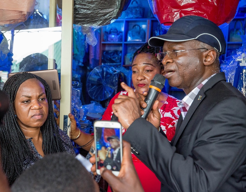 Hon Minister of Power Works  Housing Mr Babatunde FasholaSAN rightManaging DirectorCEO Rural Electrification AgencyREA Mrs Damilola Ogunbiyi right and benefitting shop owner Mrs Ngozi Joel middleduring the inspection of the electrifiedshops under the Federal Government s Energizing Economies InitiativeatAriar ia market Aba Abia State on Thursday 17th May 2018