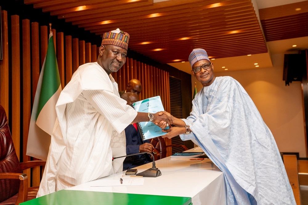 Minister of State  Works   Housing  Engr  Aliu Abubakar  left   receiving a copy of the Handing Over Note from the Permanent Secretary  Works   Housing  Mr  Mohammed Bukar right   during the resumption of duties at the Ministry by   the Minister on being sworn in at the Presidential Villa in Abuja on  Wednesday  21st August 2019