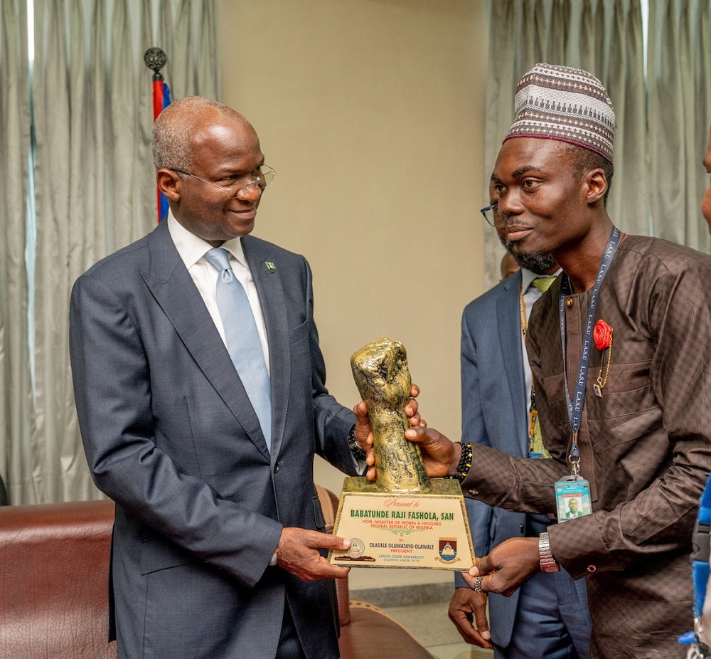 Hon  Minister of Works   Housing  Mr  Babatunde   Fashola SAN  left  being presented an art work by the President  Lagos State University s Students  Union  Mr Oladele Olawale  right   in appreciation of his contributions to the development of the School during his two term tenure as Governor   shortly before the Hon  Minister delivered the Keynote Address at   the University s 1st   Research Fair and Endowment of Research Grants Fund   with the theme   Driving National Development through Research and Innovation   at the Aderemi Makanjuola Lecture Theatre  LASU  Ojo  Lagos on Tuesday 3rd  September 2019