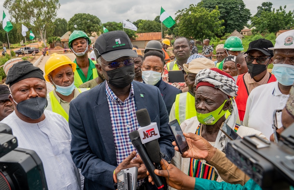 Hon. Minister of Works and Housing, Mr Babatunde Fashola,SAN (middle) flanked by the Chairman, Takum Local Government Area,Taraba State, Hon. Prince Shiban Tikari (left) and the Gara of Chachanji, Takum LGA, HRH Alhaji AbdulHamid Kumbyera while speaking with journalists shortly after the inspection of the new Chanchanji Bridge along Takum â€“ Wukari Road in Taraba State on Thursday, 12th August 2021.